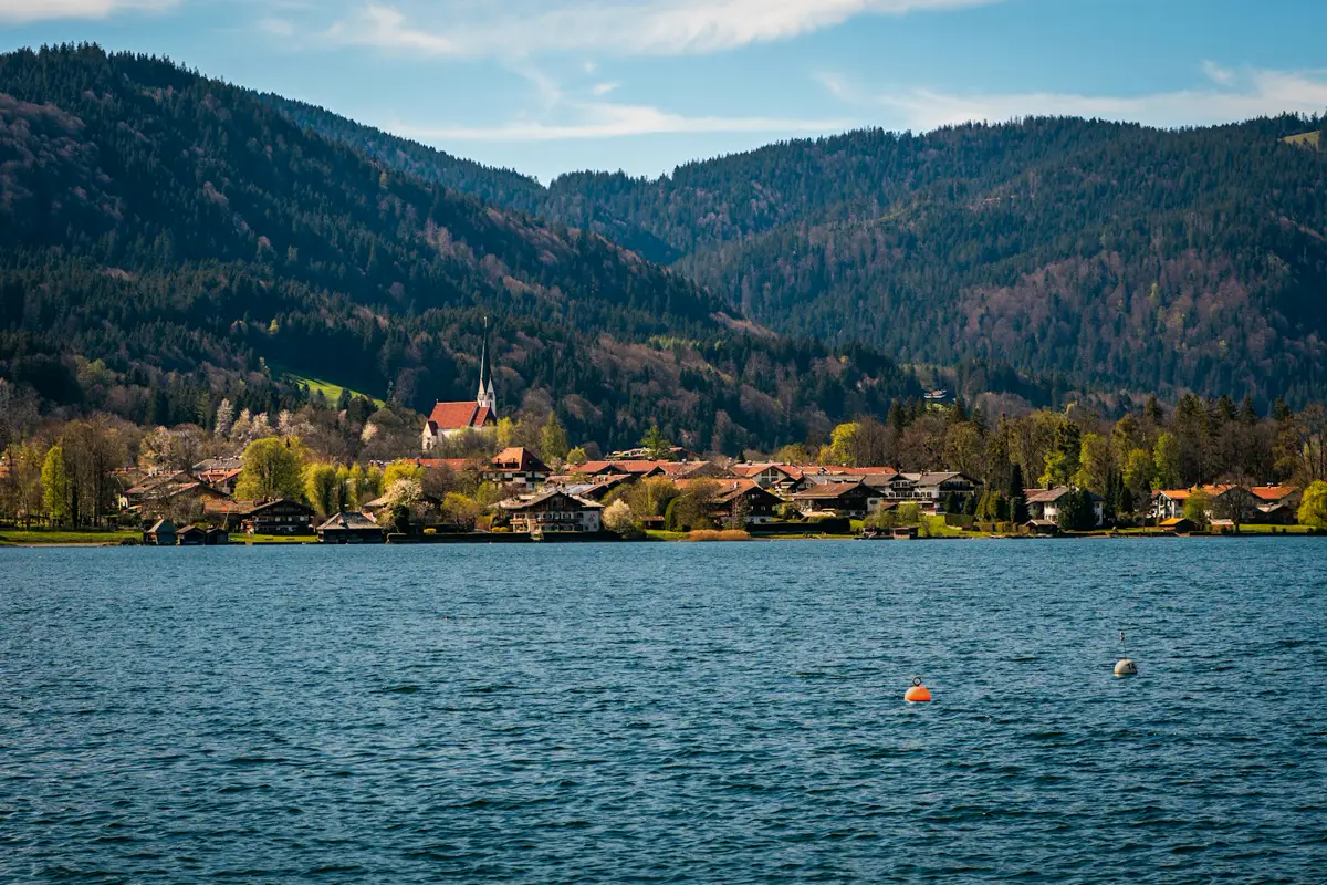 Ort am Ufer des Tegernsees mit Bergen im Hintergrund
