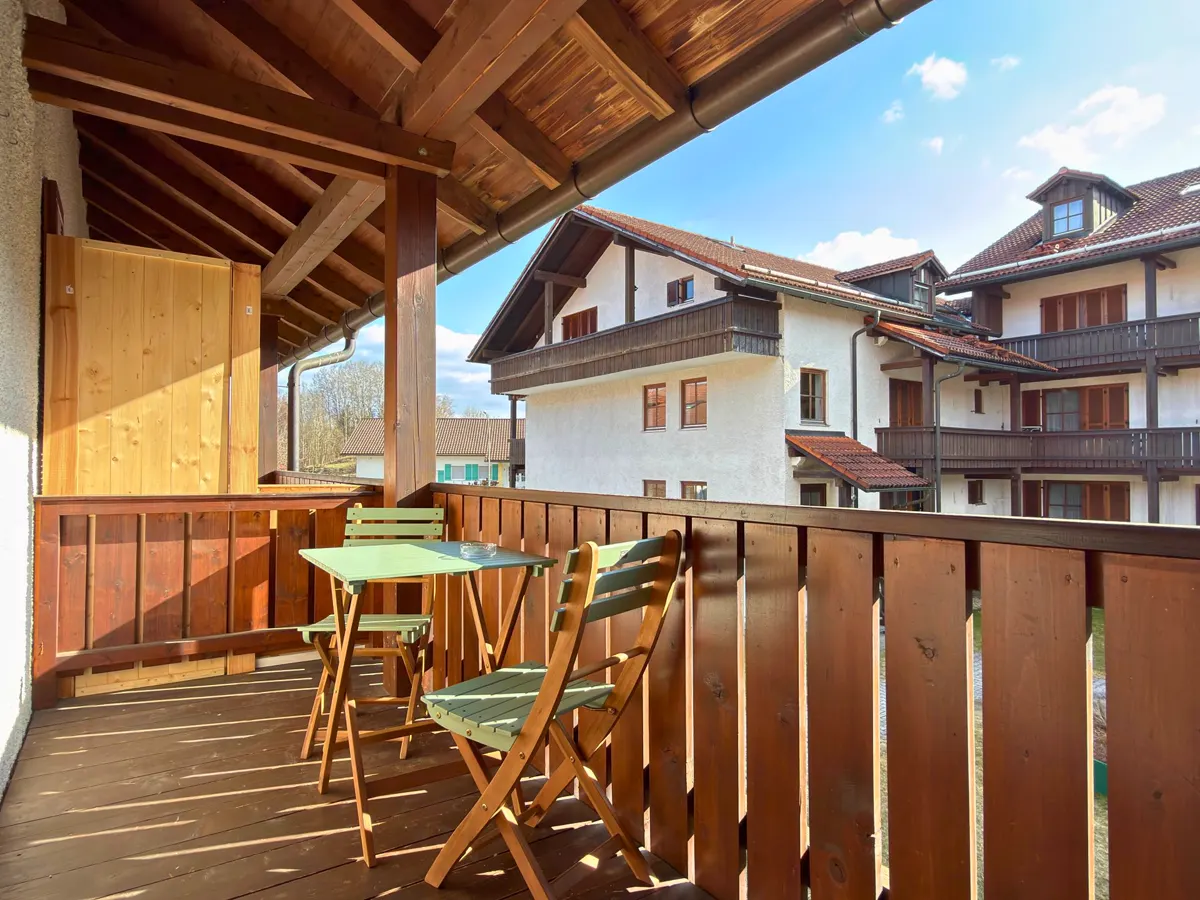 Sonniger Balkon mit Tisch und zwei Stühlen an einem Apartment in Zwiesel