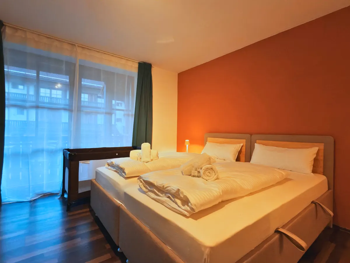 Schlafzimmer eines Apartments in Zwiesel mit gemachtem Bett und Handtüchern